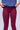 Person wearing a blue sports shirt and maroon leggings with 'CORTS' branding on a gray background.