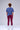 Person wearing a blue shirt and maroon leggings standing against a white background